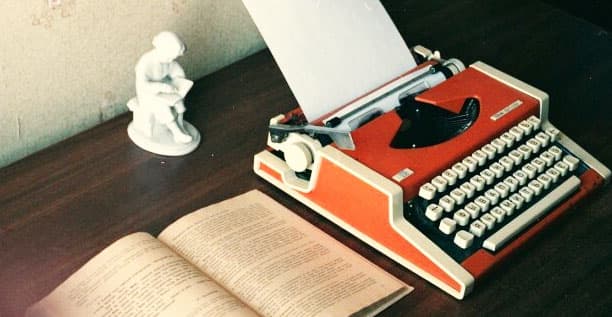 Vintage typewriter and open book on a desk